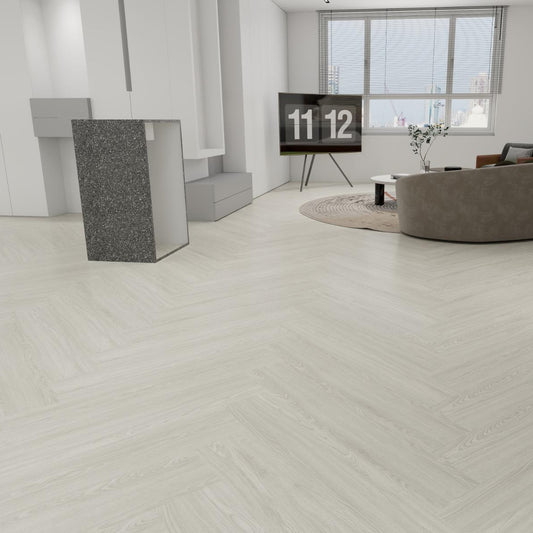 Light gray wood-look flooring shown installed in a modern, minimalist living room with a curved gray sofa, a black TV stand, and a large window.