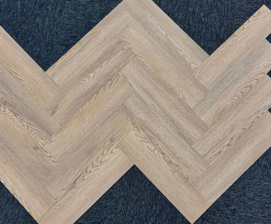 Close-up texture detail of light brown herringbone luxury vinyl tiles