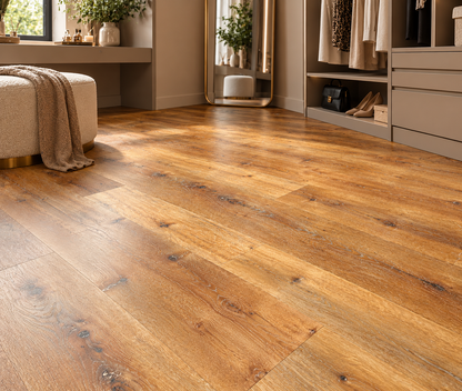 Warm medium-brown wood plank flooring shown in a styled room with a bench, draped throw, mirror, and closet area.