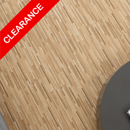 Light brown wood-look flooring planks shown from an overhead angle, with a red diagonal banner reading CLEARANCE in the top-left corner and part of a dark round table visible on the right.