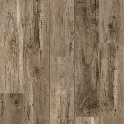 Wood-look plank flooring sample with a weathered taupe-brown grain pattern and a small QAK logo and model text along the bottom edge.